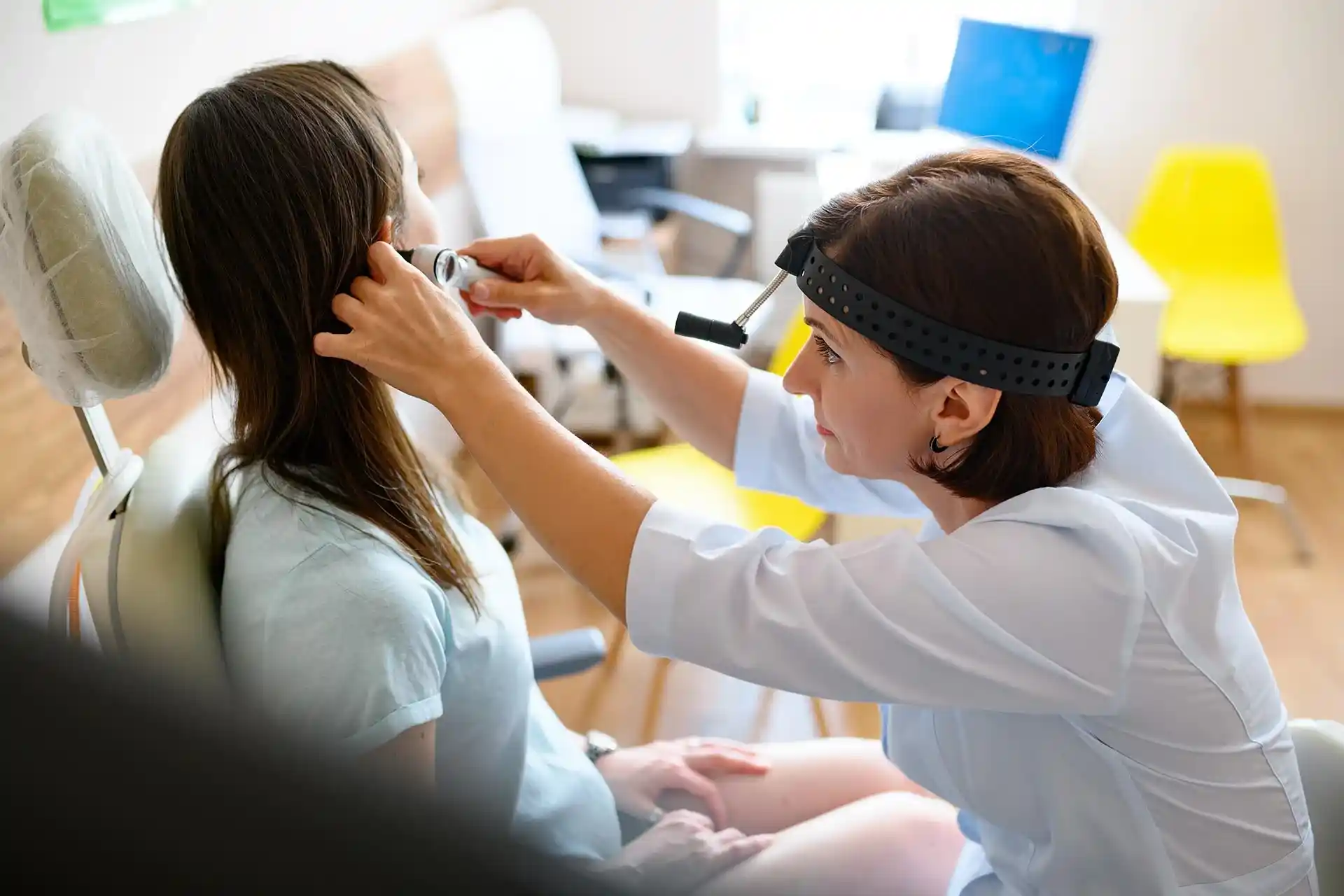 Doctor performing an ear exam on a patient at Amen Family Medicine in Livonia, MI
