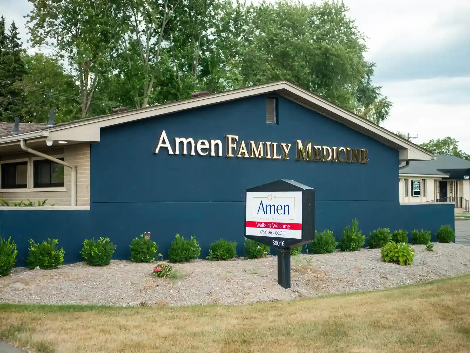 Front signage of Amen Family Medicine clinic and interior reception area located in Livonia, MI.