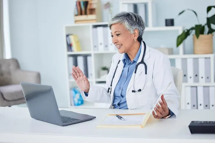 Telehealth physician reviewing patient charts while conducting an online wellness checkup in Oakland County